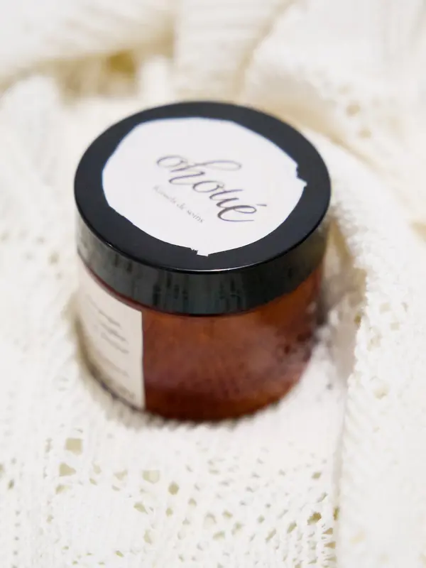 Pot ambré de Chantilly de Karité, couvercle noir estampillé Ohoué, vu du dessus sur une maille de lin crème.