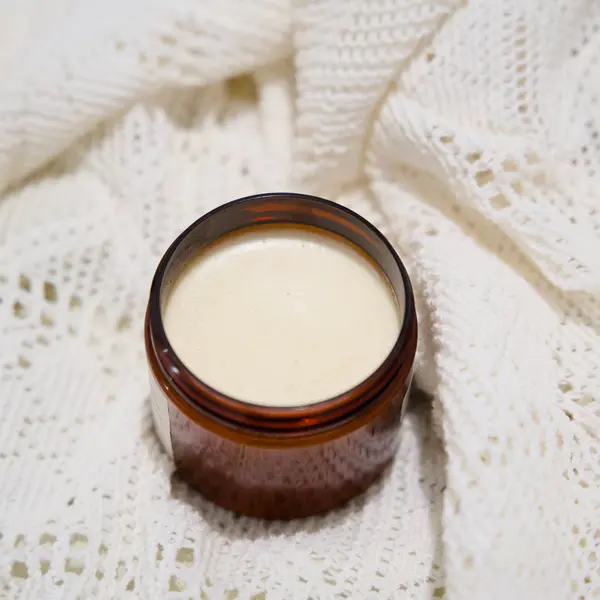 Pot de Chantilly de Karité ouvert, révélant la texture fouettée ivoire, sur fond de lin crème.