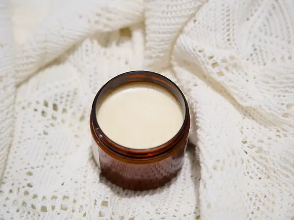 Pot de Chantilly de Karité ouvert, révélant la texture fouettée ivoire, sur fond de lin crème.